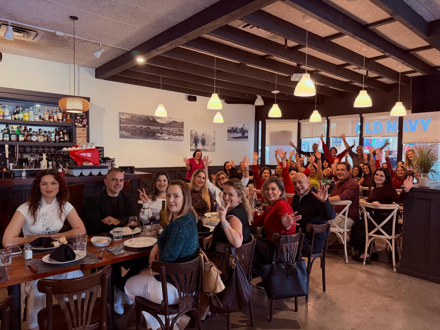 Compañeros de Safeguard and Associates reunidos alrededor de mesas de un restaurante para una celebración del equipo.