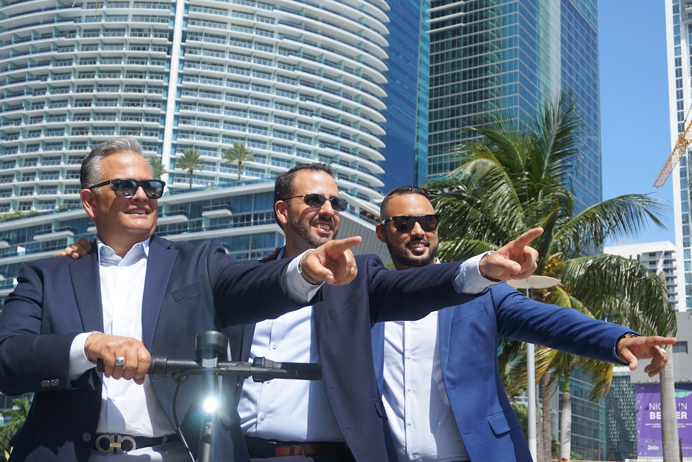 Tres personas miran y señalan hacia adelante durante una sesión fotográfica corporativa de Safeguard and Associates.